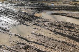 sporco argilla fango strada con pneumatico brani a giorno tempo - pieno telaio sfondo con difficile sole leggero foto