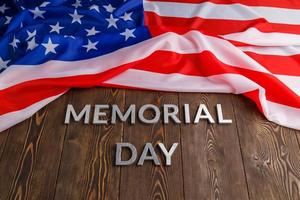 il parole memoriale giorno di cui con argento metallo lettere su di legno tavola superficie con spiegazzato Stati Uniti d'America bandiera sopra foto