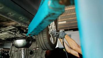 meccanico Lavorando il suo lavoro. auto su il sollevamento su macchina a il auto riparazione stazione. fissaggio Servizi e Manutenzione. selettivo messa a fuoco foto