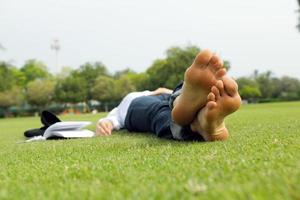 giovane donna che legge un libro nel parco foto