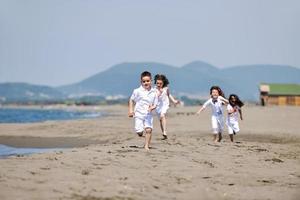 gruppo di bambini felici che giocano sulla spiaggia foto