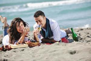 giovane coppia godendo picnic su il spiaggia foto