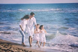 contento giovane famiglia avere divertimento su spiaggia foto