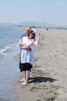 la giovane coppia felice si diverte sulla spiaggia foto