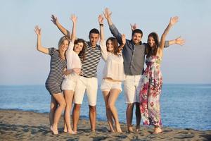 contento giovane persone gruppo avere divertimento su spiaggia foto