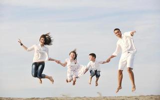 contento giovane famiglia avere divertimento su spiaggia foto