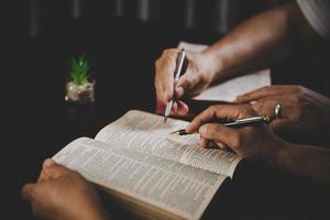 giovane donna persona mano Tenere santo Bibbia con studia a casa. adulto femmina cristiano lettura libro nel Chiesa. ragazza apprendimento religione spiritualità con pregare per Dio. concetto di alunno formazione scolastica fede. foto