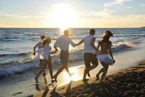 persone gruppo in esecuzione su il spiaggia foto