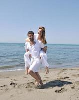 la giovane coppia felice si diverte sulla spiaggia foto