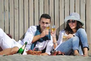 giovane coppia godendo picnic su il spiaggia foto