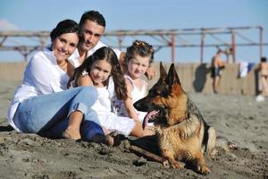 contento famiglia giocando con cane su spiaggia foto