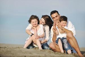 contento giovane famiglia avere divertimento su spiaggia foto