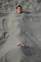 contento bambini sepolto nel sabbia foto