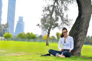 bellissimo giovane donna con tavoletta nel parco foto