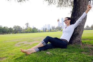 bellissimo giovane donna con tavoletta nel parco foto