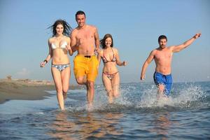 contento persone gruppo avere divertimento e in esecuzione su spiaggia foto