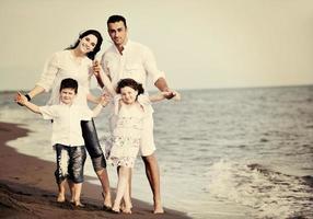 contento giovane famiglia avere divertimento su spiaggia foto