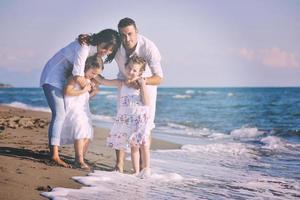 contento giovane famiglia avere divertimento su spiaggia foto