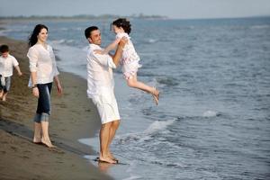 contento giovane famiglia avere divertimento su spiaggia foto