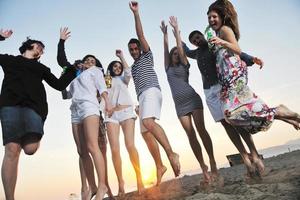 gruppo di giovane persone godere estate festa a il spiaggia foto