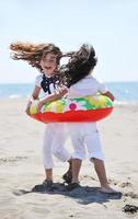 gruppo di bambini felici che giocano sulla spiaggia foto