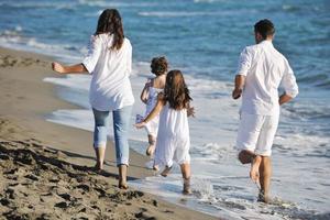 contento giovane famiglia avere divertimento su spiaggia foto