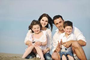 contento giovane famiglia avere divertimento su spiaggia foto