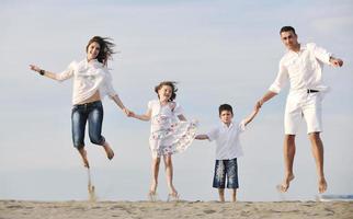 contento giovane famiglia avere divertimento su spiaggia foto