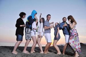 gruppo di giovane persone godere estate festa a il spiaggia foto