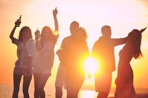 gruppo di giovane persone godere estate festa a il spiaggia foto