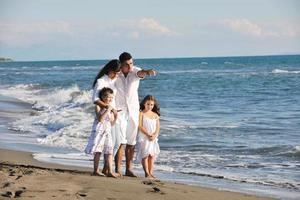 contento giovane famiglia avere divertimento su spiaggia foto