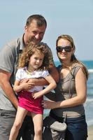 contento giovane famiglia avere divertimento su spiaggia foto