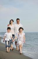 contento giovane famiglia avere divertimento su spiaggia foto