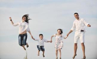 contento giovane famiglia avere divertimento su spiaggia foto