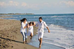 contento giovane famiglia avere divertimento su spiaggia foto