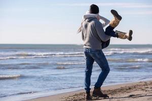 amorevole giovane coppia su un' spiaggia a autunno soleggiato giorno foto