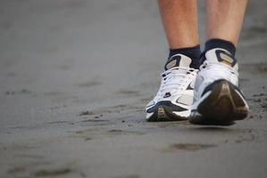 uomo a piedi su spiaggia foto