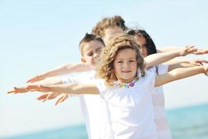 gruppo di bambini felici che giocano sulla spiaggia foto