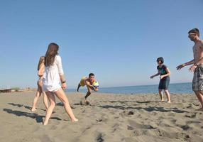 giovane persone gruppo avere divertimento e giocare spiaggia pallavolo foto