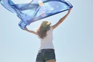 bellissimo giovane donna su spiaggia con sciarpa foto