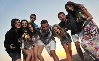 gruppo di giovane persone godere estate festa a il spiaggia foto