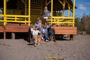 gruppo di amici avendo divertimento su autunno giorno a spiaggia foto