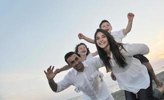 contento giovane famiglia avere divertimento su spiaggia foto