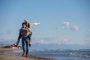 coppia avendo divertimento a spiaggia durante autunno foto