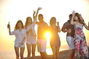 gruppo di giovane persone godere estate festa a il spiaggia foto