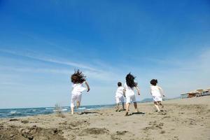 gruppo di bambini felici che giocano sulla spiaggia foto