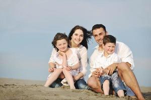 contento giovane famiglia avere divertimento su spiaggia foto