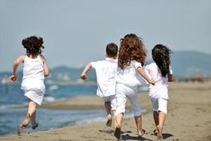 gruppo di bambini felici che giocano sulla spiaggia foto