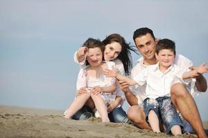 contento giovane famiglia avere divertimento su spiaggia foto