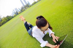 bellissimo giovane donna con tavoletta nel parco foto